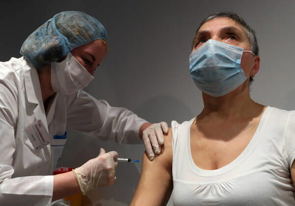 MOSCOW, RUSSIA - JANUARY 18, 2021: A man receives an injection in a mobile COVID-19 vaccination unit at the GUM department store. Alexander Shcherbak TASS  TS0F47C4