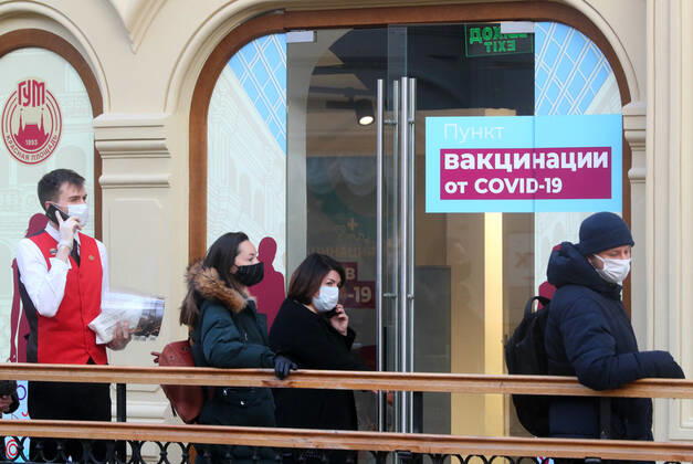 MOSCOW, RUSSIA - JANUARY 18, 2021: Citizens queue outside a mobile COVID-19 vaccination unit at the GUM department store. Alexander Shcherbak TASS  TS0F47D5