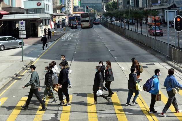 (210118) -- HONG KONG, Jan. 18, 2021 -- People wearing face masks walk on the street in south China s Hong Kong, Jan. 18, 2021. Hong Kong s Center for Health Protection (CHP) reported 107 additional confirmed cases of COVID-19 on Monday, a new high in about one month. The new cases included 102 local infections and five imported ones, taking its total tally to 9,664. More than 40 of the new local cases were untraceable and there were about 50 cases tested positive preliminarily, according to a CHP press briefing. ) CHINA-HONG KONG-COVID-19(CN) LoxPingxFai