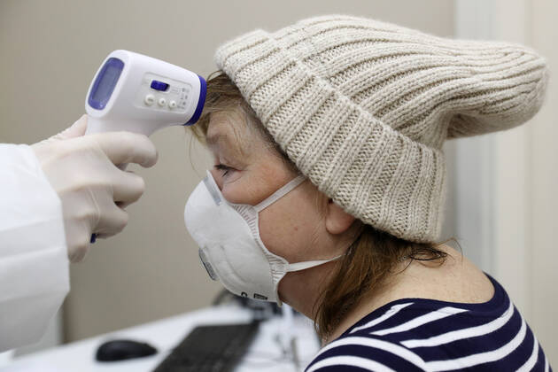 MOSCOW, RUSSIA - JANUARY 18, 2021: A woman has her body temperature measured ahead of being vaccinated with Gam-COVID-Vac (Sputnik V), a COVID-19 vaccine, at a private clinic of the Medsi chain. Sergei Savostyanov TASS  TS0F4888