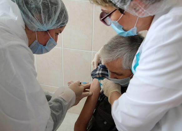 VOLGOGRAD, RUSSIA - JANUARY 18, 2021: A man is vaccinated with Gam-COVID-Vac (Sputnik V), a COVID-19 vaccine, at the Volgograd nursing home for the elderly and disabled. Dmitry Rogulin TASS  TS0F48A9