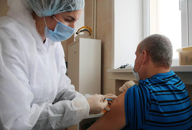 VOLGOGRAD, RUSSIA - JANUARY 18, 2021: A man is vaccinated with Gam-COVID-Vac (Sputnik V), a COVID-19 vaccine, at the Volgograd nursing home for the elderly and disabled. Dmitry Rogulin TASS  TS0F48AB