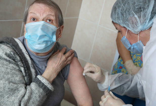 VOLGOGRAD, RUSSIA - JANUARY 18, 2021: A man is vaccinated with Gam-COVID-Vac (Sputnik V), a COVID-19 vaccine, at the Volgograd nursing home for the elderly and disabled. Dmitry Rogulin TASS  TS0F48B0