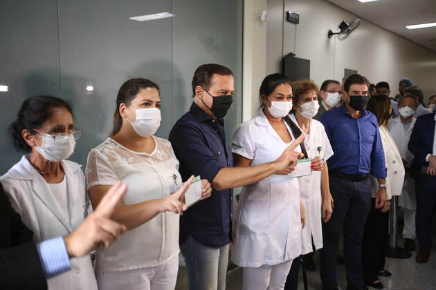 RIBEIRÃO PRETO, SP - 19.01.2021: VACINAÇÃO EM RIBEIRÃO PRETO - The governor of São Paulo, João Doria, surrounded by cameras, vaccinates the nursing technician Maria Luci Santos (right, blonde) and Juliana Badia, brunette (left) at the Hospital das Clínicas campus of Ribeirão Preto, in the interior of São Paulo. x2020341x  JoelxSilva
