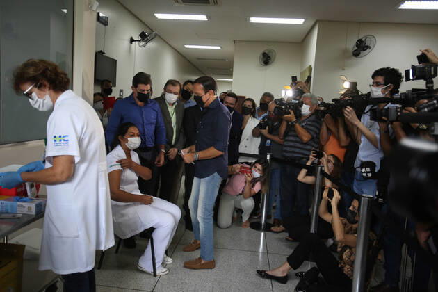 RIBEIRÃO PRETO, SP - 19.01.2021: VACINAÇÃO EM RIBEIRÃO PRETO - The governor of São Paulo, João Doria, surrounded by cameras, vaccinates the nursing technician Maria Luci Santos (right, blonde) and Juliana Badia, brunette (left) at the Hospital das Clínicas campus of Ribeirão Preto, in the interior of São Paulo. x2020359x  JoelxSilva