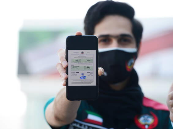 (210119) -- HAWALLI GOVERNORATE, Jan. 19, 2021 -- An employee of the Kuwaiti Ministry of Health shows the COVID-19 vaccine certificate at the vaccination center in Hawalli Governorate, Kuwait, Jan. 19, 2021. (Photo by Xinhua) KUWAIT-HAWALLI GOVERNORATE-COVID-19-VACCINATION Asad 