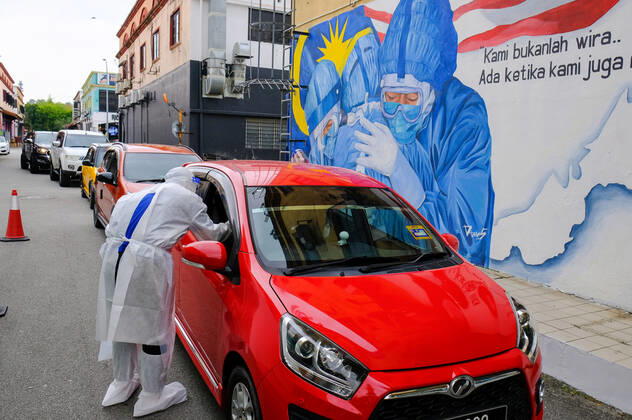 January 19, 2021, Shah Alam, Selangor, Malaysia: A medical personnel from Nur Ajwa private clinic takes a swab sample during the Covid-19 drive-thru screening test at Shah Alam...A medical personal from Nur Ajwa private clinic wears a personal protective equipment (PPE) suit seen during a Covid-19 drive-thru screening test at Shah Alam, Selangor...Ismail Sabri Yaakob the Malaysia Senior Minister has announced that all states in Malaysia will be on Movement Control Order (MCO) except the state of Sarawak. Malaysia had recorded 3,631 new cases of Covid-19 today which bring the total up to 165,371 cases. Shah Alam Malaysia - ZUMAs197 20210119_zaa_s197_038 Copyright: xFarisxHadziqx