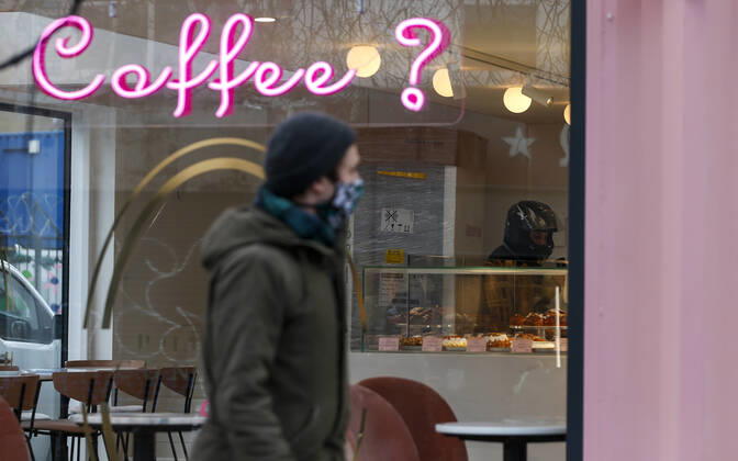 (210120) -- LONDON, Jan. 20, 2021 -- A man wearing a face mask walks past a cafe only open for takeaways in London, Britain, on Jan. 19, 2021. The number of people who have died within 28 days of a positive coronavirus test has surpassed the grim milestone of 90,000 in Britain after another 1,610 were confirmed, according to official figures released Tuesday. The latest daily death toll, the highest since the pandemic began in the country, brought the total number of coronavirus-related deaths in Britain to 91,470, the data showed. ) BRITAIN-LONDON-COVID-19-DEATH TOLL HanxYan