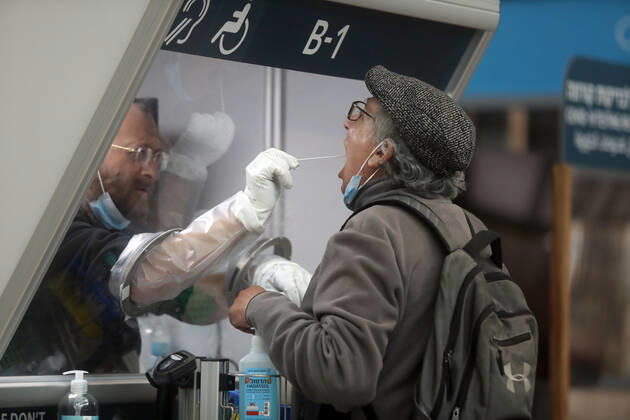 (210120) -- TEL AVIV, Jan. 20, 2021 -- A staff member takes samples from a passenger at a COVID-19 testing booth at Ben Gurion International Airport near Tel Aviv, Israel, Jan. 19, 2021. Israel s cabinet decided on Tuesday to extend by 10 days a weeks-long nationwide lockdown to curb the spread of the COVID-19 pandemic. The ministers voted in favor of extending the tight lockdown until Jan. 31, according to a cabinet statement. The cabinet also decided that travelers entering the country will be required to present a negative coronavirus test taken within 72 hours before their flight. (Gideon Markowicz JINI via Xinhua) ISRAEL-TEL AVIV-AIRPORT-COVID-19 ShangxHao 