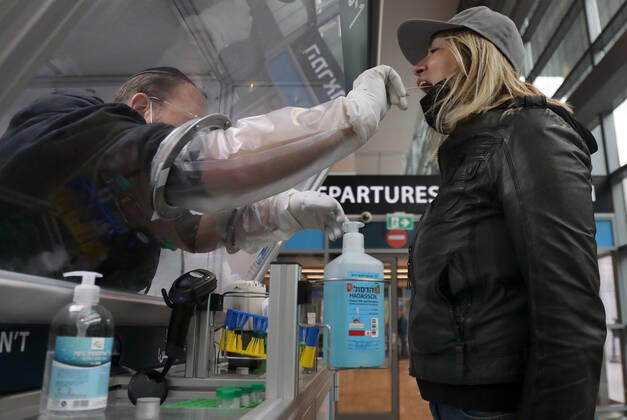 (210120) -- TEL AVIV, Jan. 20, 2021 -- A staff member takes samples from a passenger at a COVID-19 testing booth at Ben Gurion International Airport near Tel Aviv, Israel, Jan. 19, 2021. Israel s cabinet decided on Tuesday to extend by 10 days a weeks-long nationwide lockdown to curb the spread of the COVID-19 pandemic. The ministers voted in favor of extending the tight lockdown until Jan. 31, according to a cabinet statement. The cabinet also decided that travelers entering the country will be required to present a negative coronavirus test taken within 72 hours before their flight. (Gideon Markowicz JINI via Xinhua) ISRAEL-TEL AVIV-AIRPORT-COVID-19 ShangxHao 