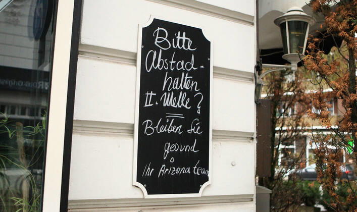 Auf einer Tafel an einem wegen des Lockdowns geschlossenem Restaurant wird dazu aufgefordert, Abstand zu halten. Zudem wird die zweite Welle der Coronavirus-Pandemie durch ein Fragezeichen hinter Zweite Welle offenbar bezweifelt. Winterhude Hamburg