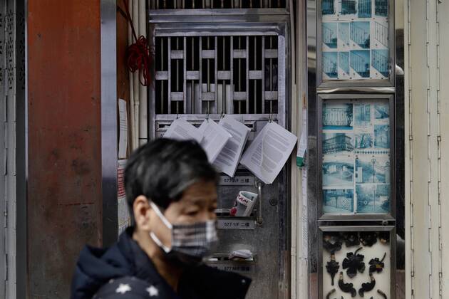 January 20, 2021, Hong Kong, CHINA: Woman walk past an aged building where identified Covid-19 patients were found, on the iron gate are notification by HK Government warning that the building is already sealed-off and controlled under restriction order.Jan-20,2021Hong Kong.ZUMA Hong Kong CHINA - ZUMAl137 20210120_zap_l137_006 Copyright: xLiauxChung-renx