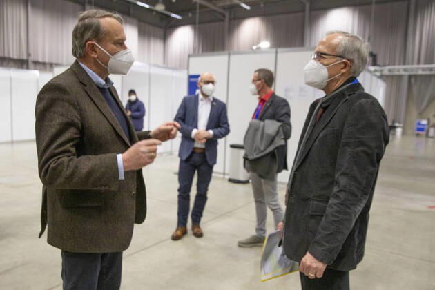 Frankfurt (Oder), 20.01.2021 - Eroeffnung des Frankfurter Impfzentrums auf dem Messegelände in Frankfurt (Oder) Der Landrat von Oder-Spree, Rolf Lindemann (links) im Gespraech mit Dipl-Med.Andreas Schwark, vom Vorstand der Kassenaerztlichen Vereinigung Brandenburgs. Im Hintergrund OB Rene Wilke und Dezernent, Jens-Marcel Ullrich (hinten rechts).