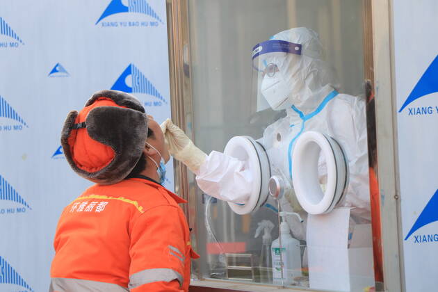 BEIJING, CHINA - JANUARY 20: A medical worker standing in an isolation booth collects a throat swab from a man for nucleic acid testing at a square in Xicheng district on January 20, 2021 in Beijing, China.  Copyright: xVCGx CFP111314272534