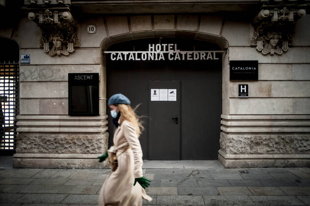January 21, 2021, Barcelona, Spain: A woman wearing a face mask walks past a closed and boarded-up hotel in Barcelona. The coronavirus pandemic has sunk hotel investment in Barcelona in 2020 by 41 percent compared to the previous year, last year the sector suffered a 95 percent drop in billing and customers in hotels. Recently, the Catalan regional government has once again reduced the capacity of establishments, has limited the opening of bars and restaurants and has tightened the requirements for social gatherings or curfew hours, which makes it impossible for visitors to arrive in Barcelona. Over the last few weeks, more than 50 hotels in the city have closed. Barcelona Spain - ZUMAb137 20210121_zap_b137_005 Copyright: xJordixBoixareux
