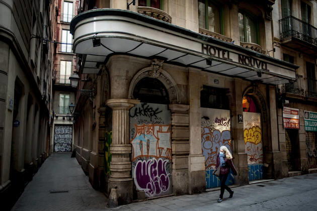 January 21, 2021, Barcelona, Spain: A woman wearing a face mask walks past a closed and boarded-up hotel in Barcelona. The coronavirus pandemic has sunk hotel investment in Barcelona in 2020 by 41 percent compared to the previous year, last year the sector suffered a 95 percent drop in billing and customers in hotels. Recently, the Catalan regional government has once again reduced the capacity of establishments, has limited the opening of bars and restaurants and has tightened the requirements for social gatherings or curfew hours, which makes it impossible for visitors to arrive in Barcelona. Over the last few weeks, more than 50 hotels in the city have closed. Barcelona Spain - ZUMAb137 20210121_zap_b137_008 Copyright: xJordixBoixareux