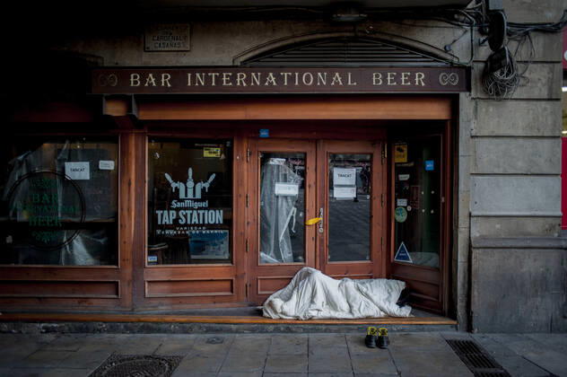 January 21, 2021, Barcelona, Spain: Homeless man sleeps close the restaurant of a closed hostel in Barcelona. The coronavirus pandemic has sunk hotel investment in Barcelona in 2020 by 41 percent compared to the previous year, last year the sector suffered a 95 percent drop in billing and customers in hotels. Recently, the Catalan regional government has once again reduced the capacity of establishments, has limited the opening of bars and restaurants and has tightened the requirements for social gatherings or curfew hours, which makes it impossible for visitors to arrive in Barcelona. Over the last few weeks, more than 50 hotels in the city have closed. Barcelona Spain - ZUMAb137 20210121_zap_b137_010 Copyright: xJordixBoixareux