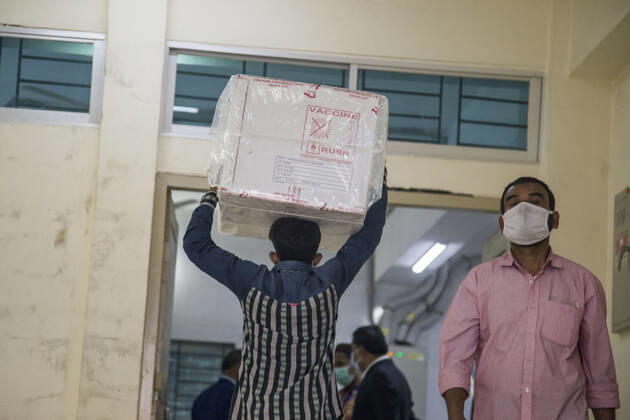 January 21, 2021, Dhaka, Bangladesh: A worker carries a carton of Oxford-AstraZeneca COVID-19 vaccines that arrived from India to Bangladesh as a gift. Dhaka Bangladesh - ZUMAr331 20210121_zip_r331_005 Copyright: xMortuzaxRashedx