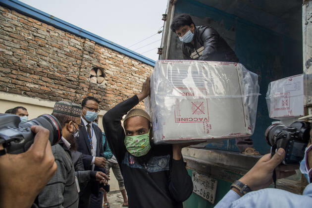 January 21, 2021, Dhaka, Bangladesh: A worker carries a carton of Oxford-AstraZeneca COVID-19 vaccines that arrived from India to Bangladesh as a gift. Dhaka Bangladesh - ZUMAr331 20210121_zip_r331_015 Copyright: xMortuzaxRashedx
