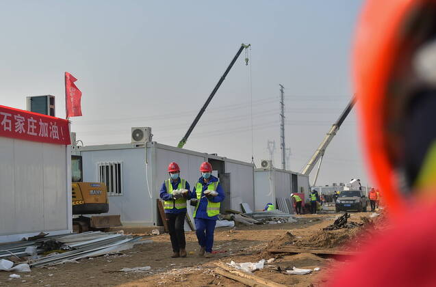 (210121) -- SHIJIAZHUANG, Jan. 21, 2021 -- Luo Chang an(L) and Luo Yandong bring lunch back at the construction site of the Huangzhuang Apartment quarantine center in Shijiazhuang, north China s Hebei Province, Jan. 21, 2021. Luo Yandong, a 22-year-old junior of Wuhan Technical College of Communications, started his internship at Second Engineering Co., Ltd. of China Railway First Group three months ago. He now participates in the construction of Huangzhuang Apartment quarantine center where his father Luo Chang an is also a worker. Located at the junction of Zhengding County and Gaocheng District in Shijiazhuang, the Huangzhuang Apartment COVID-19 quarantine center project covers an area of 658 mu (about 43.87 hectares) with a capacity 