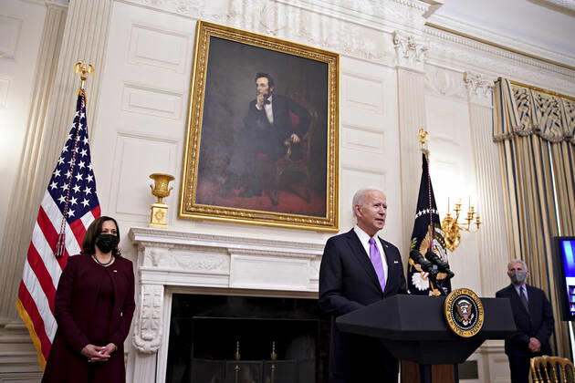U.S. President Joe Biden speaks as U.S. Vice President Kamala Harris, left, and Anthony Fauci, director of the National Institute of Allergy and Infectious Diseases, right, listen during an event on his administration s Covid-19 response in the State Dining Room of the White House in Washington, DC on Thursday, January 21, 2021.  WAX20210121934 AlxDrago
