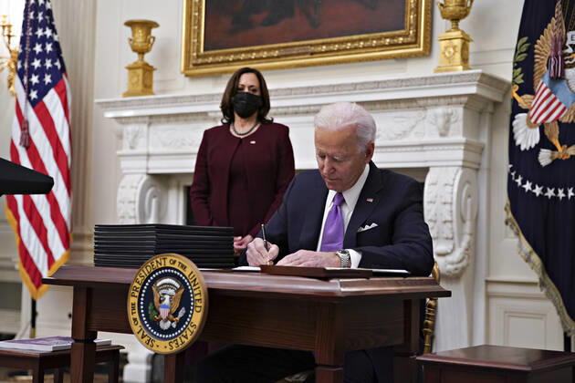 January 21, 2021, Washington, District of Columbia, USA: U.S. President Joe Biden signs an executive order after speaking during an event on his administration s Covid-19 response with U.S. Vice President Kamala Harris, left, in the State Dining Room of the White House in Washington, D.C., U.S., on Thursday, Jan. 21, 2021. Biden in his first full day in office plans to issue a sweeping set of executive orders to tackle the raging Covid-19 pandemic that will rapidly reverse or refashion many of his predecessor s most heavily criticized policies Washington USA - ZUMAs152 20210121_zaa_s152_116 Copyright: xAlxDragox-xPoolxViaxCnpx