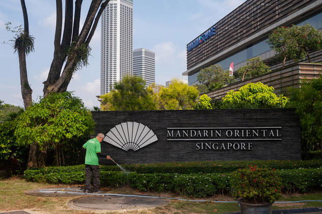 21.01.2021, Singapur, Republik Singapur, Asien - Ein Arbeiter waessert am Mandarin Oriental Hotel Singapore in Marina Square die Pflanzen. Auf Grund der andauernden Corona-Krise verbuchen viele Hotels des Stadtstaats enorme Umsatzeinbussen, da die Hotelauslastung schwer angeschlagen ist. Die stark vom Handel abhaengige Wirtschaft der Finanzmetropole erlitt im letzten Jahr auf Grund der Corona-Pandemie die schlimmste Rezession in ihrer jungen Geschichte und verzeichnete einen Rueckgang des BIP um 5,8 Prozent.