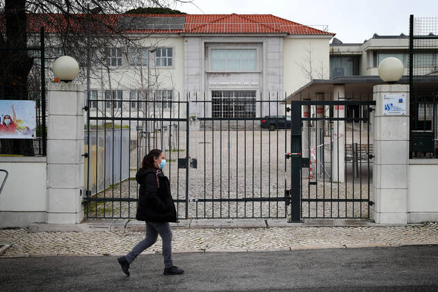 January 22, 2021, Lisbon, Portugal: A woman wearing a face mask walks by the Sebastiao e Silva closed school in Oeiras, near Lisbon on January 22, 2021. Portugal applied more tightened lockdown rules and closed schools for two weeks in a bid to contain a surge in coronavirus cases with concerns over the spread of a more contagious UK strain. Lisbon Portugal - ZUMAf123 20210122_zap_f123_008 Copyright: xPedroxFiuzax