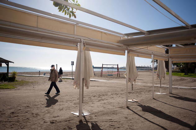 January 22, 2021, Malaga, Spain: A man wearing a face mask as a precaution against the spread of covid-19 walks past a closed beach bar at La Malagueta beach amid coronavirus pandemic..The region of Andausia suffers an uncontrolled daily rise of coronavirus cases, despite of hard restrictions imposed in the daily life. During the last weeks, Andalusia has reported thousands of infections everyday in the region while the hospital pressure continue rising. Malaga Spain - ZUMAs197 20210122_zaa_s197_040 Copyright: xJesusxMeridax