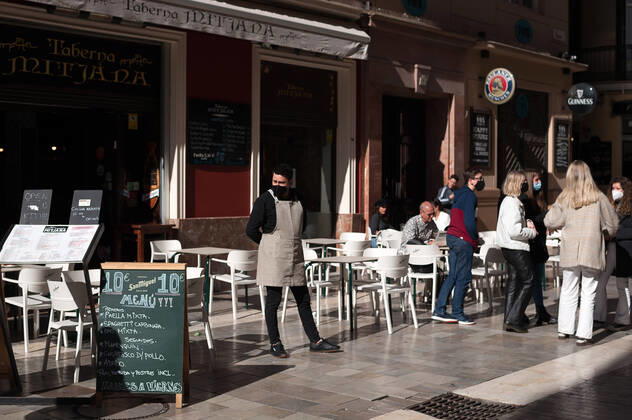 January 22, 2021, Malaga, Spain: An employee seen waiting for customers outside Mitjana bar at Caldereria street amid coronavirus pandemic..The region of Andausia suffers an uncontrolled daily rise of coronavirus cases, despite of hard restrictions imposed in the daily life. During the last weeks, Andalusia has reported thousands of infections everyday in the region while the hospital pressure continue rising. Malaga Spain - ZUMAs197 20210122_zaa_s197_042 Copyright: xJesusxMeridax