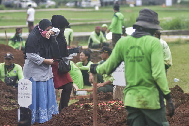 January 22, 2021, Jakarta, Indonesia: A family wearing face masks mourns as they watch the burial of a relative at Bambu Apus public cemetery..Indonesia has reported 346 deaths from Covid-19 infection on Thursday (Jan 21), hitting a new record for the second time this week, as hospitals in the South-east Asian nation come under increasing strain from the coronavirus pandemic. Data from Indonesia s Covid-19 taskforce confirms a total 27,203 deaths, while confirmed cases toll to 951,651, among the highest in Asia. Jakarta Indonesia - ZUMAs197 20210122_zaa_s197_055 Copyright: xAgungxFatmaxPutrax