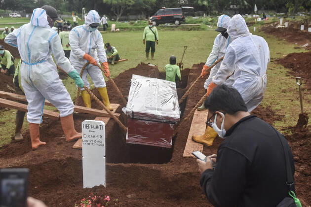 January 22, 2021, Jakarta, Indonesia: (EDITORS NOTE: Image depicts death).Undertakers wearing protective suits as a precaution lower the coffin of a covid-19 victim for burial at Bambu Apus public cemetery..Indonesia has reported 346 deaths from Covid-19 infection on Thursday (Jan 21), hitting a new record for the second time this week, as hospitals in the South-east Asian nation come under increasing strain from the coronavirus pandemic. Data from Indonesia s Covid-19 taskforce confirms a total 27,203 deaths, while confirmed cases toll to 951,651, among the highest in Asia. Jakarta Indonesia - ZUMAs197 20210122_zaa_s197_057 Copyright: xAgungxFatmaxPutrax