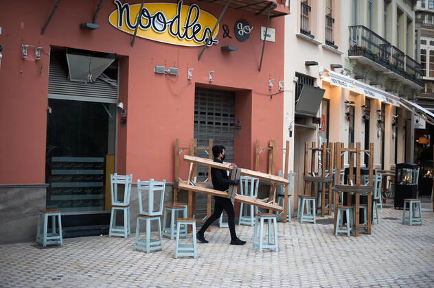 January 22, 2021, Malaga, Spain: A waiter seen carrying a group of chairs outside noodles restaurant during the mandatory closure..The third wave of coronavirus disease has impacted most daily income in the Andalusia region after the Christmas holidays. Following the increase of infections, several regional governments decided to take new measures such as limiting mobility perimeters between cities and towns and closing hospitality and commercial sectors in the afternoon. Malaga Spain - ZUMAs197 20210122_zaa_s197_074 Copyright: xJesusxMeridax