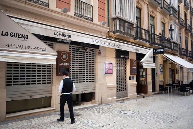 January 22, 2021, Malaga, Spain: An employee seen closing Lo Gueno restaurant at Strachan street during the mandatory closure..The third wave of coronavirus disease has impacted most daily income in the Andalusia region after the Christmas holidays. Following the increase of infections, several regional governments decided to take new measures such as limiting mobility perimeters between cities and towns and closing hospitality and commercial sectors in the afternoon. Malaga Spain - ZUMAs197 20210122_zaa_s197_079 Copyright: xJesusxMeridax