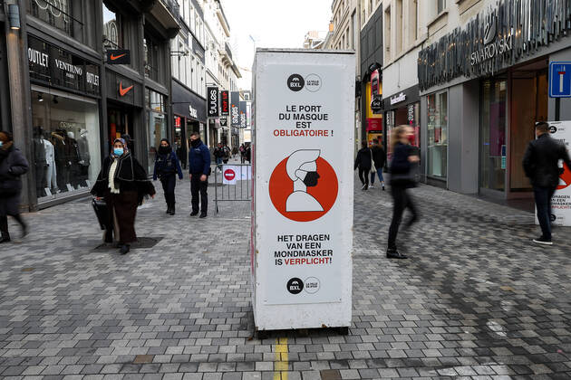 (210123) -- BRUSSELS, Jan. 23, 2021 -- People walk past a sign reminding people to wear face masks on a shopping street in Brussels, Belgium, Jan. 22, 2021. The annual Belgian winter sales kicked off on Jan. 4. To boost consumption, the scheduled four-week-long winter sales have been extended by two weeks until Feb. 15. ) BELGIUM-BRUSSELS-COVID-19-WINTER SALES ZhangxCheng 