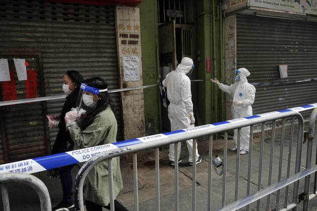 (210123) -- HONG KONG, Jan. 23, 2021 -- Staff members in protective suits are seen at work in a local specified restricted area for compulsory COVID-19 testing in Jordan, Kowloon, Hong Kong, south China, Jan. 23, 2021. The government of the Hong Kong Special Administrative Region (HKSAR) has made restriction-testing declaration and issued compulsory testing notice in respect of a local specified restricted area in a bid to cut COVID-19 spread. Residents in the area, bounded by Woosung Street to its east, Nanking Street to its south, Battery Street to its west and Kansu Street to its north, are required to stay at home until all their test results are mostly ascertained, the HKSAR government said in a statement issued early Satur