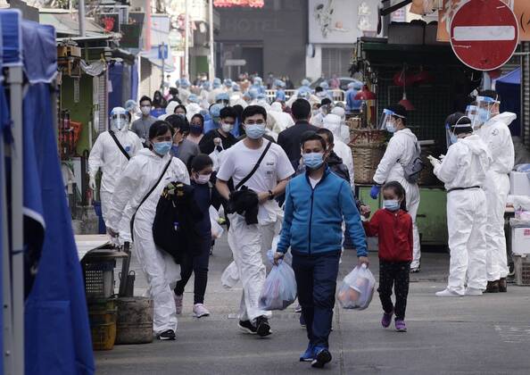 (210123) -- HONG KONG, Jan. 23, 2021 -- Residents return home after fetching daily necessities in a local specified restricted area for compulsory COVID-19 testing in Jordan, Kowloon, Hong Kong, south China, Jan. 23, 2021. The government of the Hong Kong Special Administrative Region (HKSAR) has made restriction-testing declaration and issued compulsory testing notice in respect of a local specified restricted area in a bid to cut COVID-19 spread. Residents in the area, bounded by Woosung Street to its east, Nanking Street to its south, Battery Street to its west and Kansu Street to its north, are required to stay at home until all their test results are mostly ascertained, the HKSAR government said in a statement issued early S