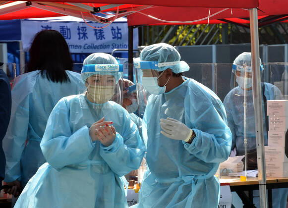 (210123) -- HONG KONG, Jan. 23, 2021 -- Medical workers are on duty at a COVID-19 nucleic acid testing station in Yuen Long, Hong Kong, south China, Jan. 23, 2021. Hong Kong s tally of COVID-19 infections surpassed 10,000 on Saturday amid the fourth wave of the epidemic outbreak. Hong Kong s Center for Health Protection reported 81 additional confirmed cases of the virus, taking the total to 10,009. Of the new cases, 78 were locally transmitted, including 35 of unknown origin. ) CHINA-HONG KONG-COVID-19-CASES (CN) LoxPingxFai