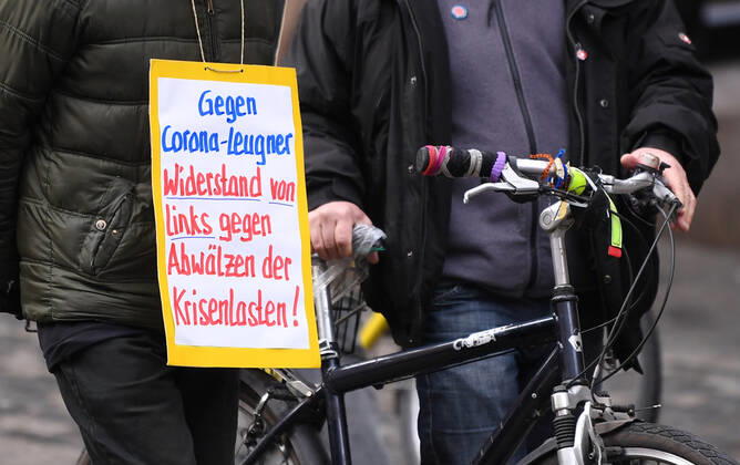 Tuebingen 23.01.2021 Themenbild, Demonstrant mit Banner in der Tuebinger Innenstadt: Gegen Corona -Leugner, Widerstandvon links gegen Abwaelzer der Krisenlasten!