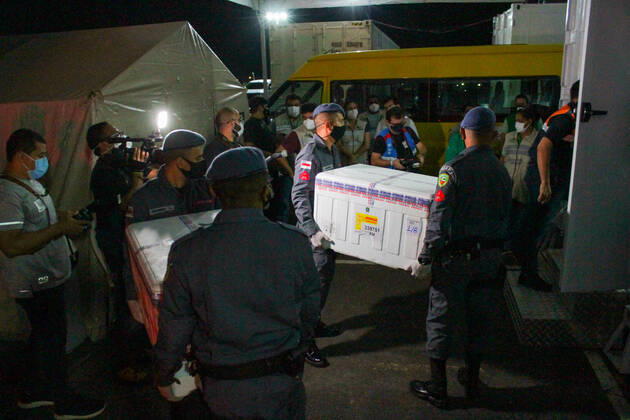 MANAUS, AM - 24.01.2021: CHEGADA DAS VACINAS ASTRAZENECA EM MANAUS - Arrival of the 132,500 doses of the AstraZeneca Oxford vaccine, this Saturday night (23), in Manaus (AM), at Eduardo Gomes International Airport. The boxes with the vaccines were taken to the headquarters of the Health Surveillance Foundation (FVS-AM). In the photo, soldiers of the PM help to unload the boxes with vaccines at the headquarters of FVS-AM. x2023653x  SandroxPereira