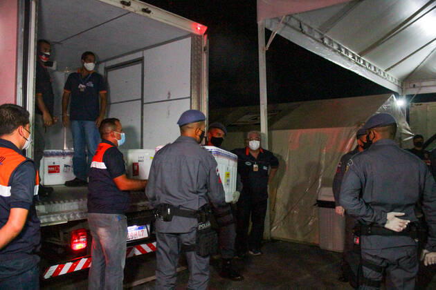 MANAUS, AM - 24.01.2021: CHEGADA DAS VACINAS ASTRAZENECA EM MANAUS - Arrival of the 132,500 doses of the AstraZeneca Oxford vaccine, this Saturday night (23), in Manaus (AM), at Eduardo Gomes International Airport. The boxes with the vaccines were taken to the headquarters of the Health Surveillance Foundation (FVS-AM). In the photo, soldiers of the PM help to unload the boxes with vaccines at the headquarters of FVS-AM. x2023665x  SandroxPereira