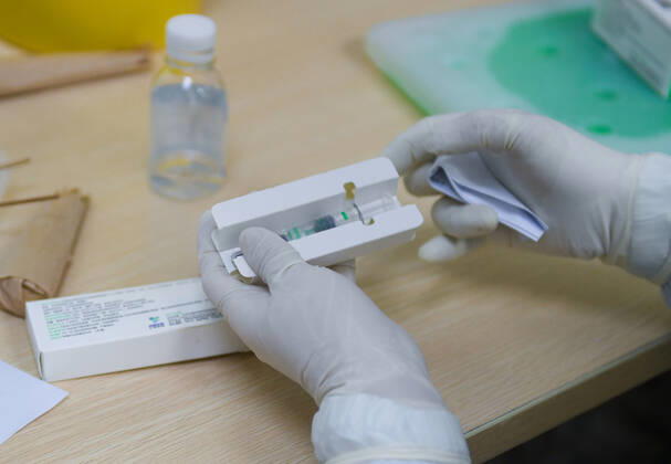 (210124) -- SHENZHEN, Jan. 24, 2021 -- A nurse prepares a dose of COVID-19 vaccine at the health service center of the Xiameilin community in Futian District, Shenzhen, south China s Guangdong Province, Jan. 24, 2021. The Shenzhen Bus Group Co., Ltd. encourages its employees to receive COVID-19 vaccines. By Friday, there are 11,004 employees having received the first shot. The inoculation of the second shot kicked off on Sunday and some 1,400 people are expected to take the shots by the end of the day. ) CHINA-SHENZHEN-COVID-19-VACCINATION-SECOND DOSE (CN) MaoxSiqian