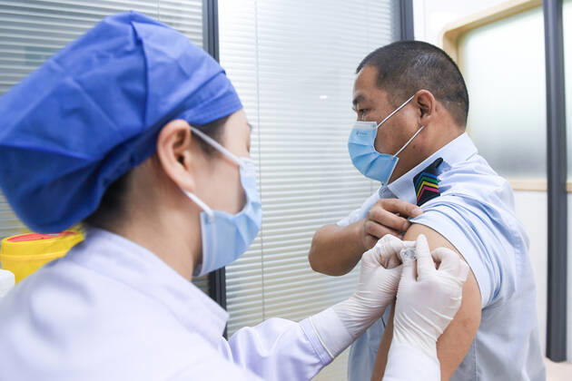(210124) -- SHENZHEN, Jan. 24, 2021 -- A nurse administers the second dose of COVID-19 vaccine to a driver of the Shenzhen Bus Group Co., Ltd. at the health service center of the Xiameilin community in Futian District, Shenzhen, south China s Guangdong Province, Jan. 24, 2021. The Shenzhen Bus Group Co., Ltd. encourages its employees to receive COVID-19 vaccines. By Friday, there are 11,004 employees having received the first shot. The inoculation of the second shot kicked off on Sunday and some 1,400 people are expected to take the shots by the end of the day. ) CHINA-SHENZHEN-COVID-19-VACCINATION-SECOND DOSE (CN) MaoxSiqian