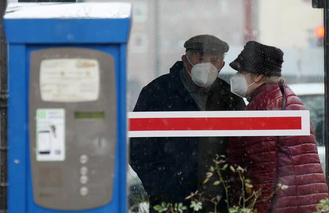 Winter wetter mit Schnee , older couple with Safety Mask FFP2 are seen at Bus Stop during the Hard Lockdown of the Covid 19 Coronavirus Pandemie in Nuremberg Nurnberg , Bayern , Deutschland . January 24 , 2021.