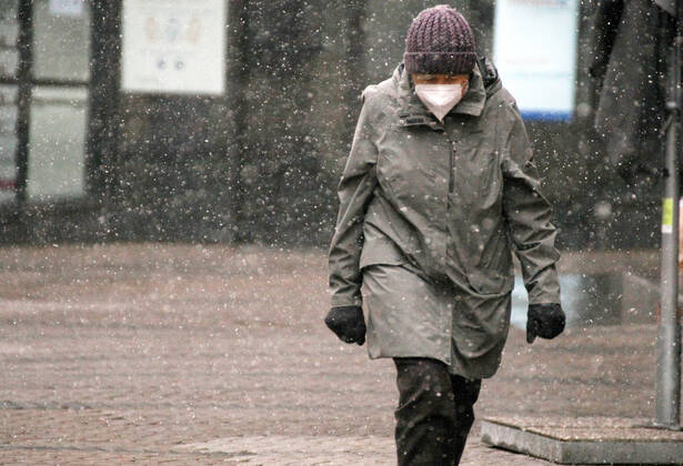 Winter wetter mit Schnee , an old women with Safety mask FFP2 is seen under the snow during the Hard Lockdown of the Covid 19 Coronavirus Pandemie in Nuremberg Nurnberg , Bayern , Deutschland . January 24 , 2021.