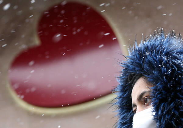 Winter wetter mit Schnee , herz , Saint Valentine , a women with Safety mask FFP2 is seen under the snow during the Hard Lockdown of the Covid 19 Coronavirus Pandemie in Nuremberg Nurnberg , Bayern , Deutschland . January 24 , 2021.
