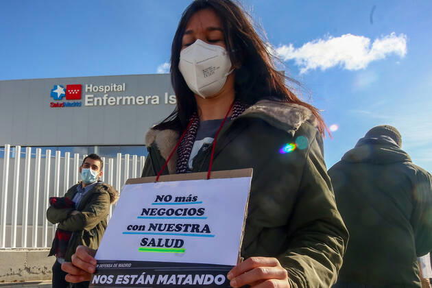 A health worker holds a cartel that reads: No more business with our health during a demonstration to demand a halt to the dismantling of the staff and resources of Madrid s public hospitals outside the Nurse Isabel Zendal Emergency Hospital in Madrid, Spain, on 24 January 2021. The platform Sanitarios Necesarios Madrid has called for the protest due to the forced transfer of public health workers to this hospital located in Valdebebas and for the transfer of economic resources to provide its infrastructure. 24 JANUARY 2021;HEALTH;PANDEMIC;CORONAVIRUS;HOSPITAL;INFECTED Ricardo Rubio LagenciaEP 01 24 2021 Madrid Madrid Spain Copyright: xRicardoxRubiox 3532398