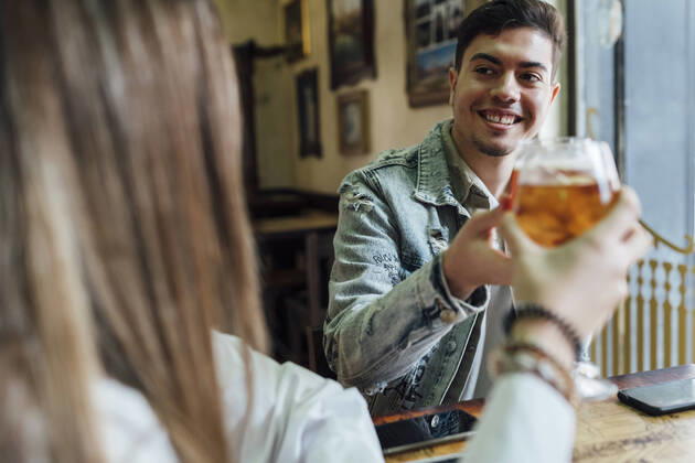 IMAGO Creative: Landleben - Essen Happy friends smiling while toasting drinks in bar model released Symbolfoto property released EGAF01286