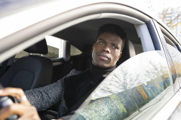 Young man driving car model released Symbolfoto JCCMF00793
