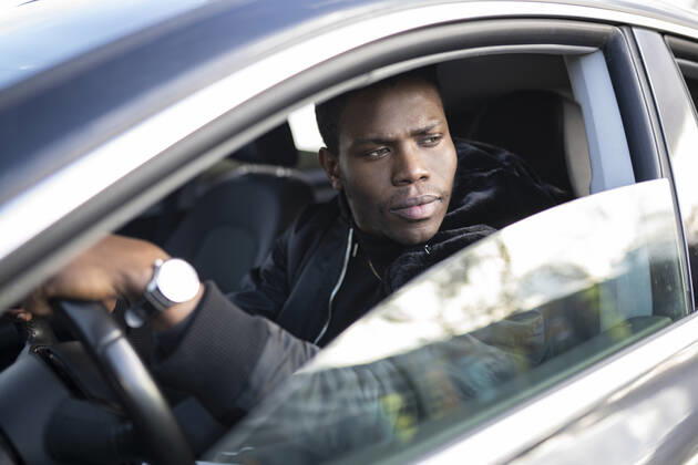 Young man driving car model released Symbolfoto JCCMF00811